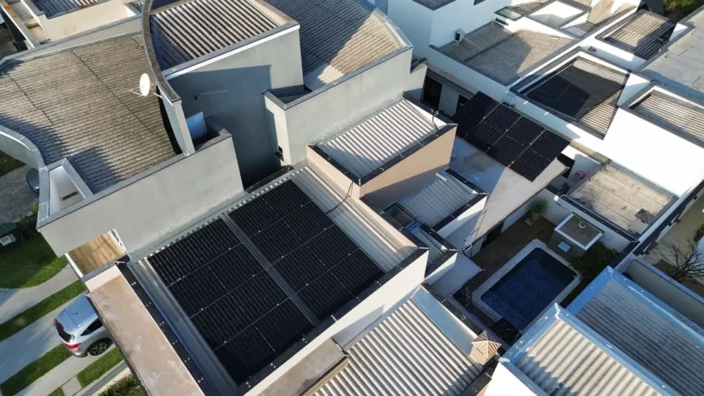 instalação fotovoltaica Sorocaba em telhado residencial, equipe técnica realizando montagem de módulos solares, estrutura de fixação segura e integração com inversor para geração de energia elétrica